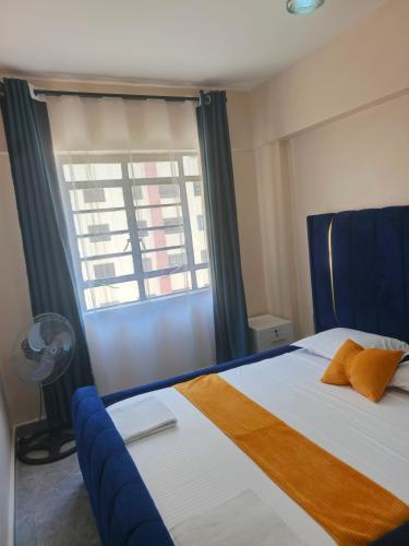 a bedroom with a large bed with a window at Kate's Ksm CBD apartments 3br2br1br O7Oo1FourFour22Eight in Kisumu