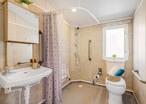 a bathroom with a sink and a toilet and a shower at Aber Bay Holiday Park in Aberystwyth