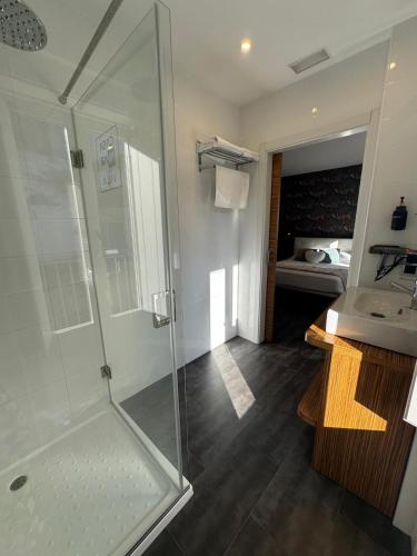 a bathroom with a glass shower and a sink at Casa Mar da Vila in Noya