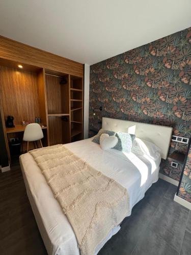 a bedroom with a large bed with a floral accent wall at Casa Mar da Vila in Noya