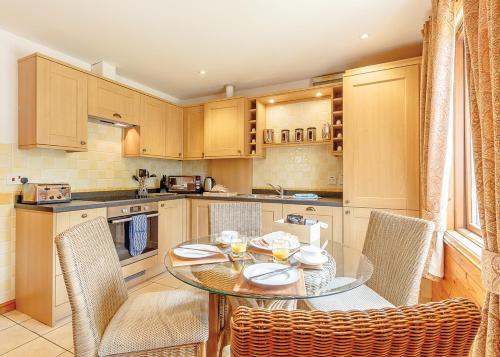 a kitchen with a glass table and chairs in a kitchen at Tilford Woods Lodge Retreat in Farnham