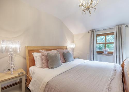 a bedroom with a bed with white sheets and pillows at Charlesworth Lodges in Glossop
