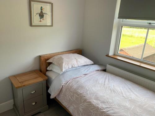 a small bedroom with a bed and a window at Catcleugh Bridge View in Kielder