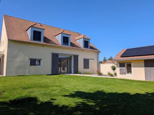 a house with a green lawn in front of it at Les Hôtes des Maillets 