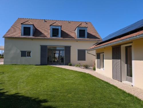 a house with a green lawn in front of it at Les Hôtes des Maillets 