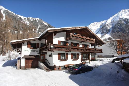 a house with a car parked in front of it in the snow at Haus Bergkristall in Längenfeld
