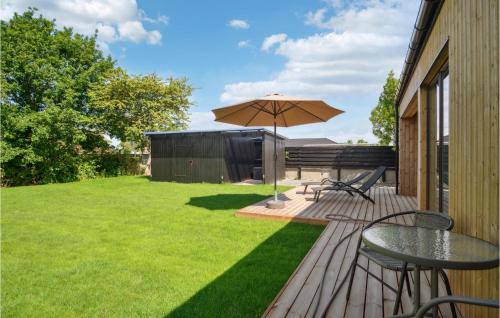 a patio with a table and an umbrella at Cozy Home In Samsø With Kitchen in Onsbjerg