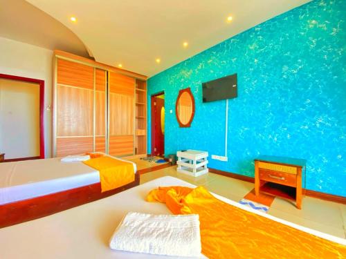a bedroom with a large bed and a blue wall at Shanzu Oceanfront Apartments and Suites in Mombasa