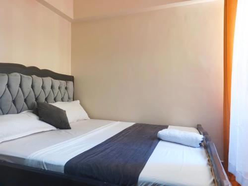 a bed in a small room with a large bed sidx sidx sidx at Kate's Ksm CBD apartments 3br2br1br O7Oo1FourFour22Eight in Kisumu