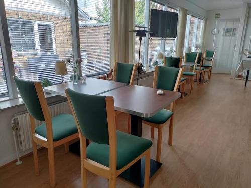 a conference room with a table and green chairs at Pejsehaven in Nørre Snede