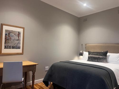 a bedroom with a bed and a desk with a table at 2 on Fairview in Kloof