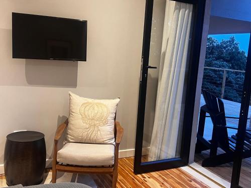 a living room with a chair and a flat screen tv at 2 on Fairview in Kloof