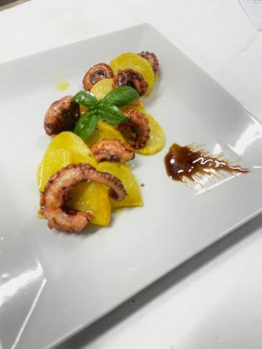 a plate of food with shrimp and peppers and a fork at Hotel Chiaro di Luna in Marina di Ascea