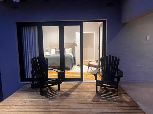 two chairs sitting in a room with a bedroom at 2 on Fairview in Kloof