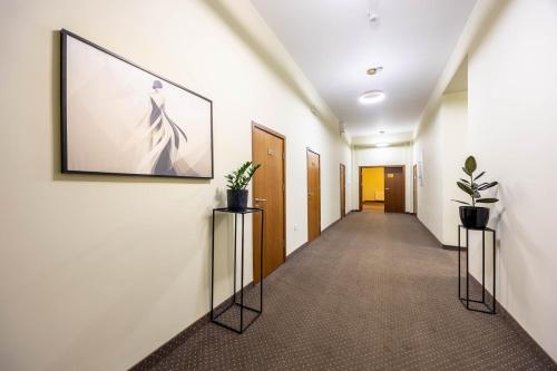 a hallway with a picture of a dress on the wall at Hotel Lothus in Wrocław