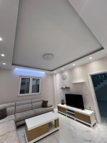 a living room with a couch and a flat screen tv at Miri House in Domje