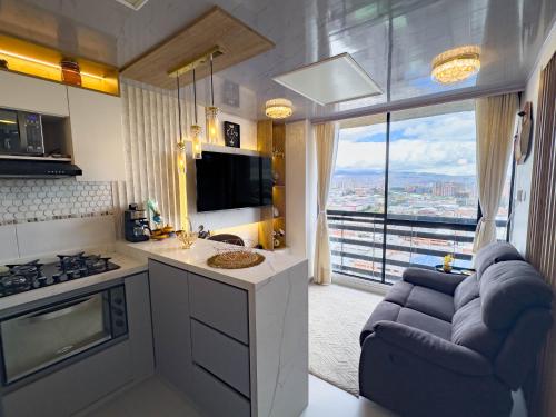a kitchen with a living room with a couch and a tv at Top views, airport, Salitre, American embassy, parking in Bogotá