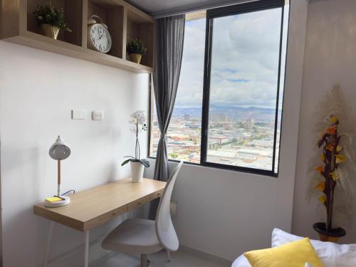 a desk and chair in a room with a window at Top views, airport, Salitre, American embassy, parking in Bogotá