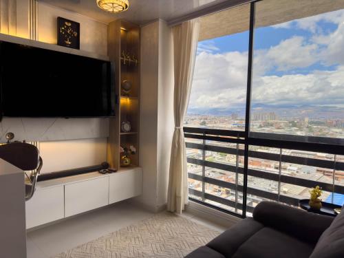 a living room with a large window and a television at Top views, airport, Salitre, American embassy, parking in Bogotá