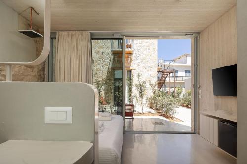 una stanza con un letto e una porta scorrevole in vetro di Hub Hospitality a Chania