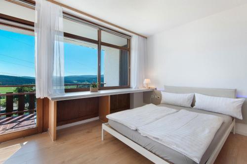 a bedroom with a bed and a large window at Fewo S22 in Regen