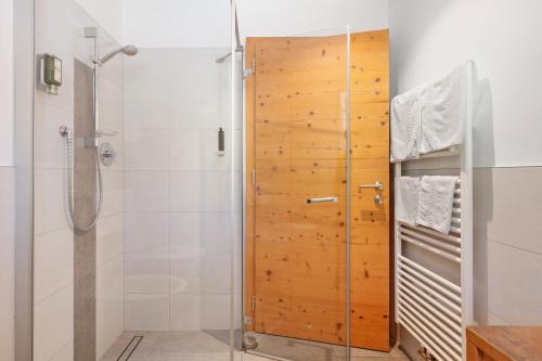 a shower with a wooden door in a bathroom at Hotel Residence Olympia Sarntal in Sarntal
