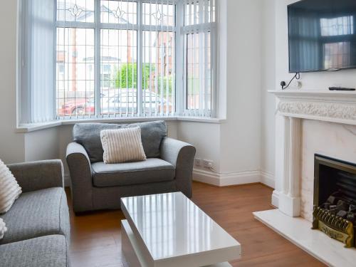 a living room with two chairs and a fireplace at Rose And Jay House in Bridlington