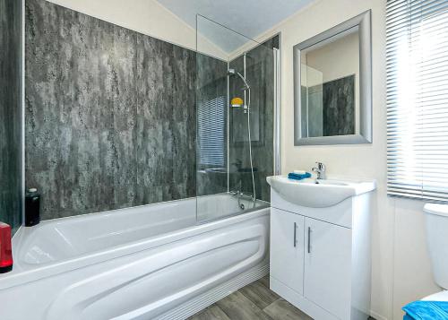 a bathroom with a white tub and a sink and a bath tub at Springhouse Country Park in Slaley