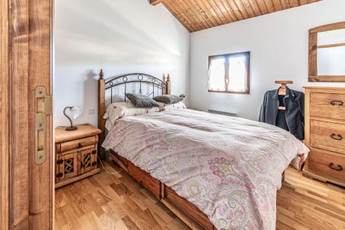 a bedroom with a large bed and a wooden dresser at House with garden and fireplace in Osséja
