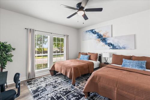 ダラスにあるDallas Haven- Pool, Game Room, Outdoor Funのベッド2台と天井ファン付きの寝室
