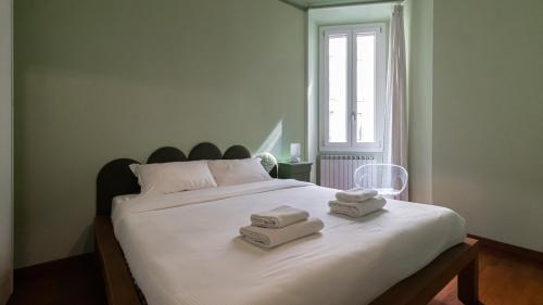 a bedroom with a large white bed with towels on it at Italianway - Tadino 1 B in Milan
