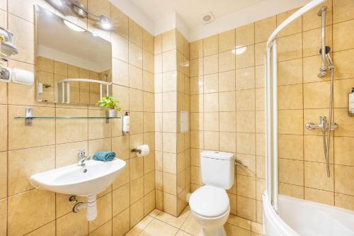 a bathroom with a toilet and a sink and a shower at Hotel Polonia Centrum in Wrocław