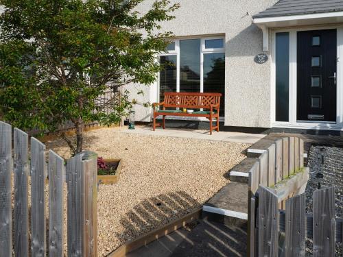a wooden bench sitting in front of a house at Haven View in Berwick-Upon-Tweed