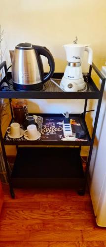 a shelf with a coffee pot and cups on it at Quiet Tortellini in Modena