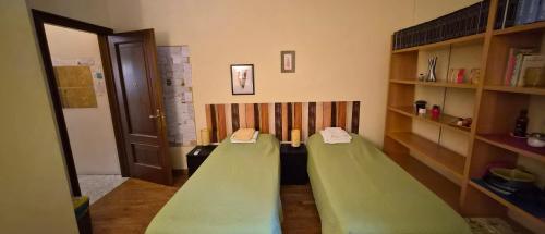 a room with two green beds in a room at Quiet Tortellini in Modena