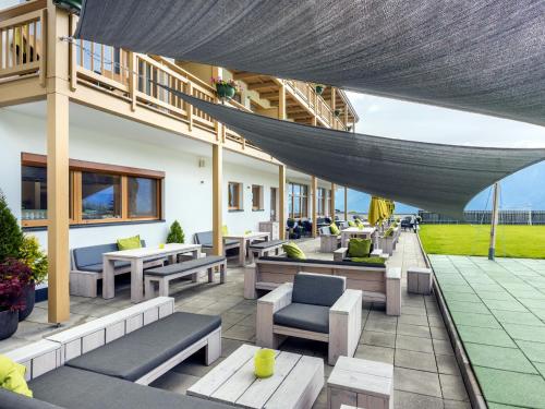 an outdoor patio with couches and chairs and tables at Natürlich Hotel mit Charakter in Fiss