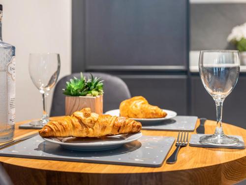 a table with two plates of croissants and glasses of wine at The Flowing River in Ulverston
