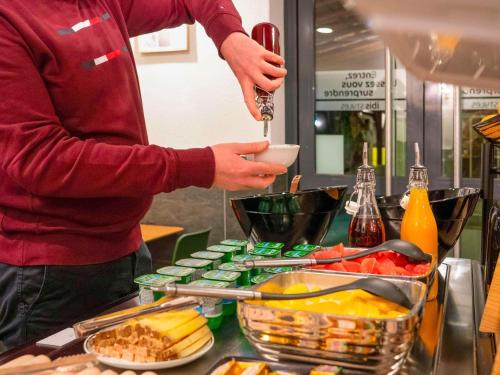 a person is preparing food on a counter at ibis Styles Nancy Centre Gare in Nancy