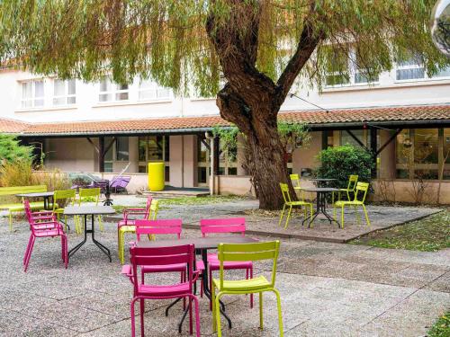 a group of tables and chairs under a tree at ibis Styles Nancy Centre Gare in Nancy