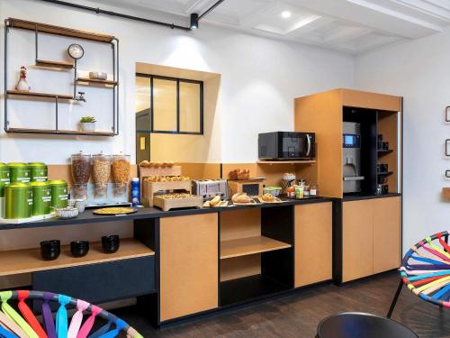 a kitchen with a counter with food on it at ibis Styles Macon Centre in Mâcon