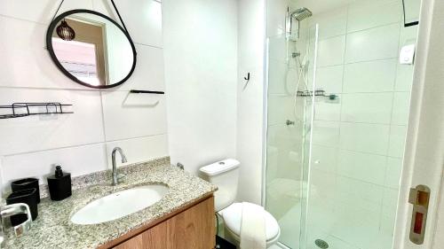 a bathroom with a sink and a glass shower at Conforto na Liberdade - AC e Quarto privativo in Sao Paulo