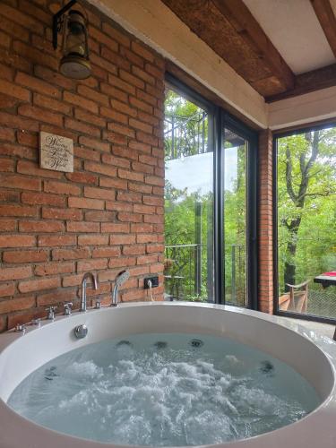 a large bath tub in a room with a window at Villa Vejini cabin in Mamkoda
