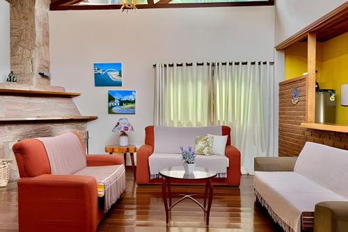 a living room with two chairs and a table at Studio Lua Nova - Cabanas Lua Nova in Penedo