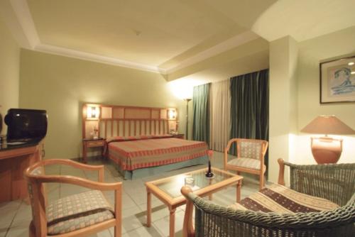 a hotel room with a bed and a couch and chairs at Sea Garden Hotel in Hurghada