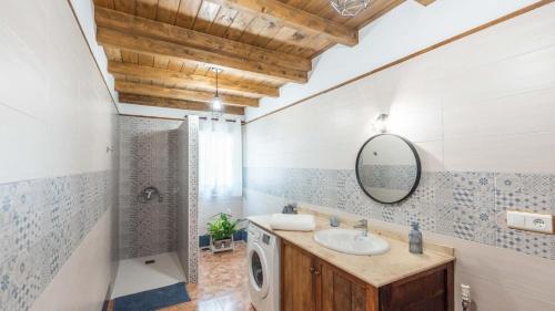 a bathroom with a sink and a washing machine at Casa La Sombra de la Parra Antequera - La Higuera by Ruralidays in Antequera