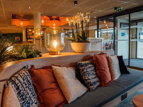 a bench with pillows on it in a store at ibis Bayeux Port En Bessin in Port-en-Bessin-Huppain