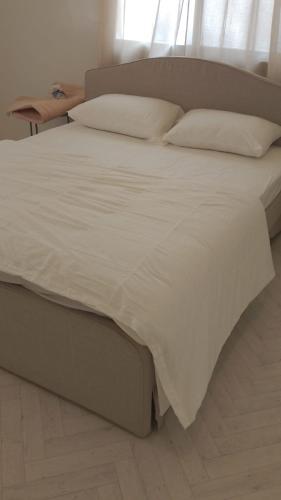 a large bed with white sheets and pillows at بيت الضباب in Abha
