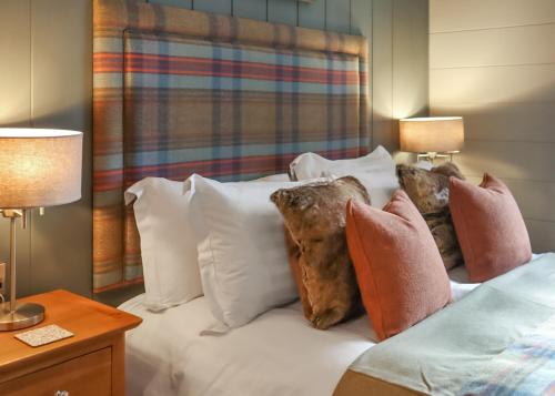 a bedroom with a bed with pillows on it at Thirlestane Woodland Lodges in Lauder