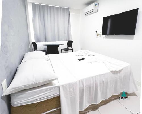 a hospital room with a white table and a tv at Brisa do Mar Apartments in Fortaleza