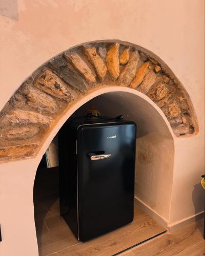 a black refrigerator in front of a brick oven at Spago rooms 2 in Vieste